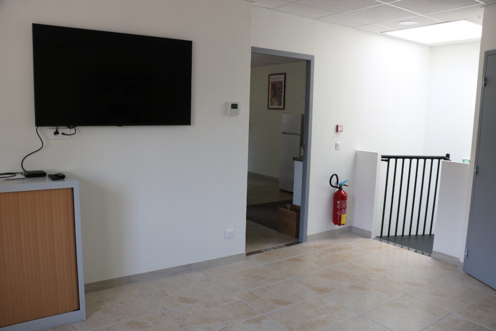 Grande salle polyvalente avec écran TV
